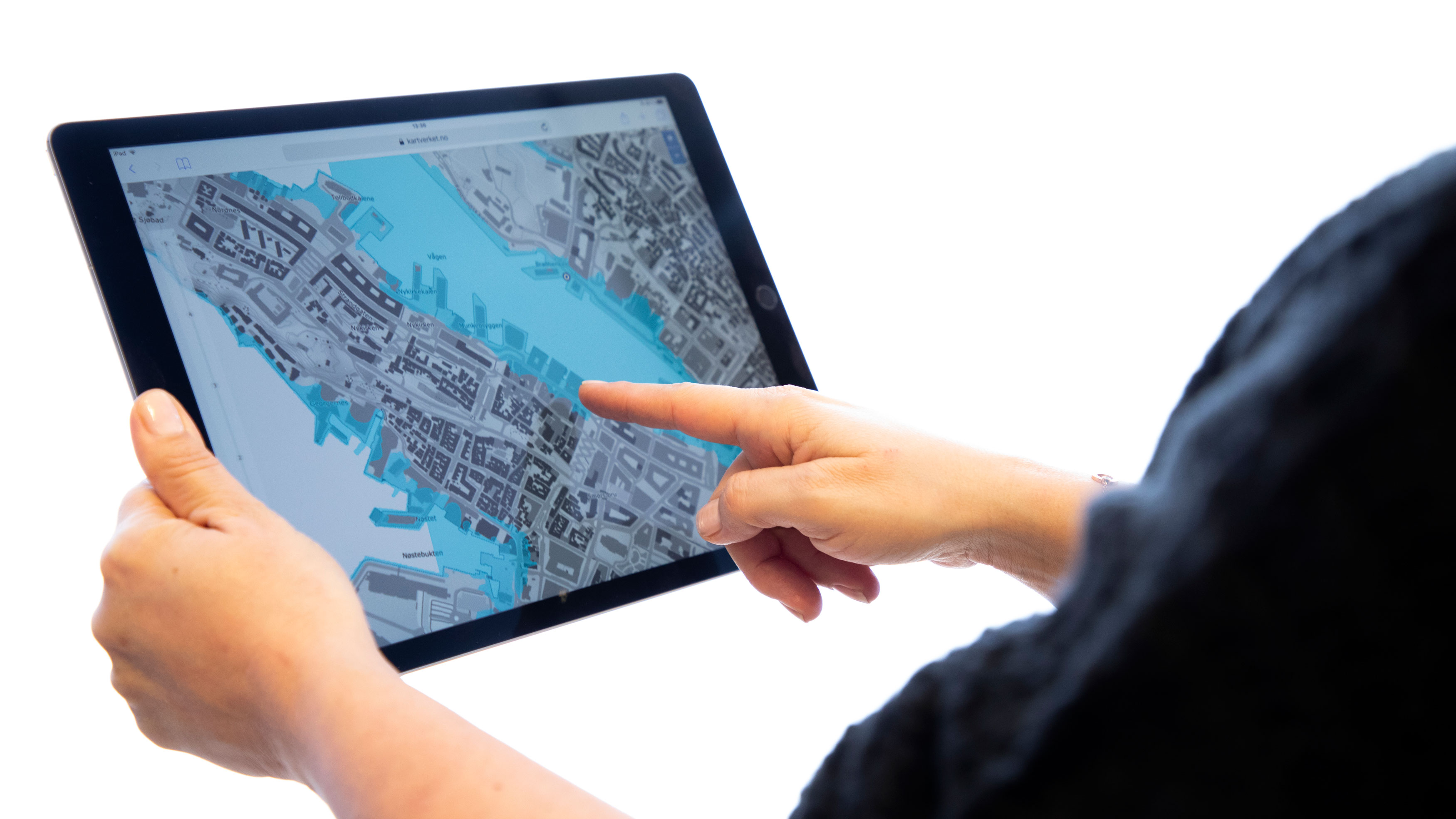 Hånd peker i nettjenesten Se havnivå i kart vist på et nettbrett. Foto.