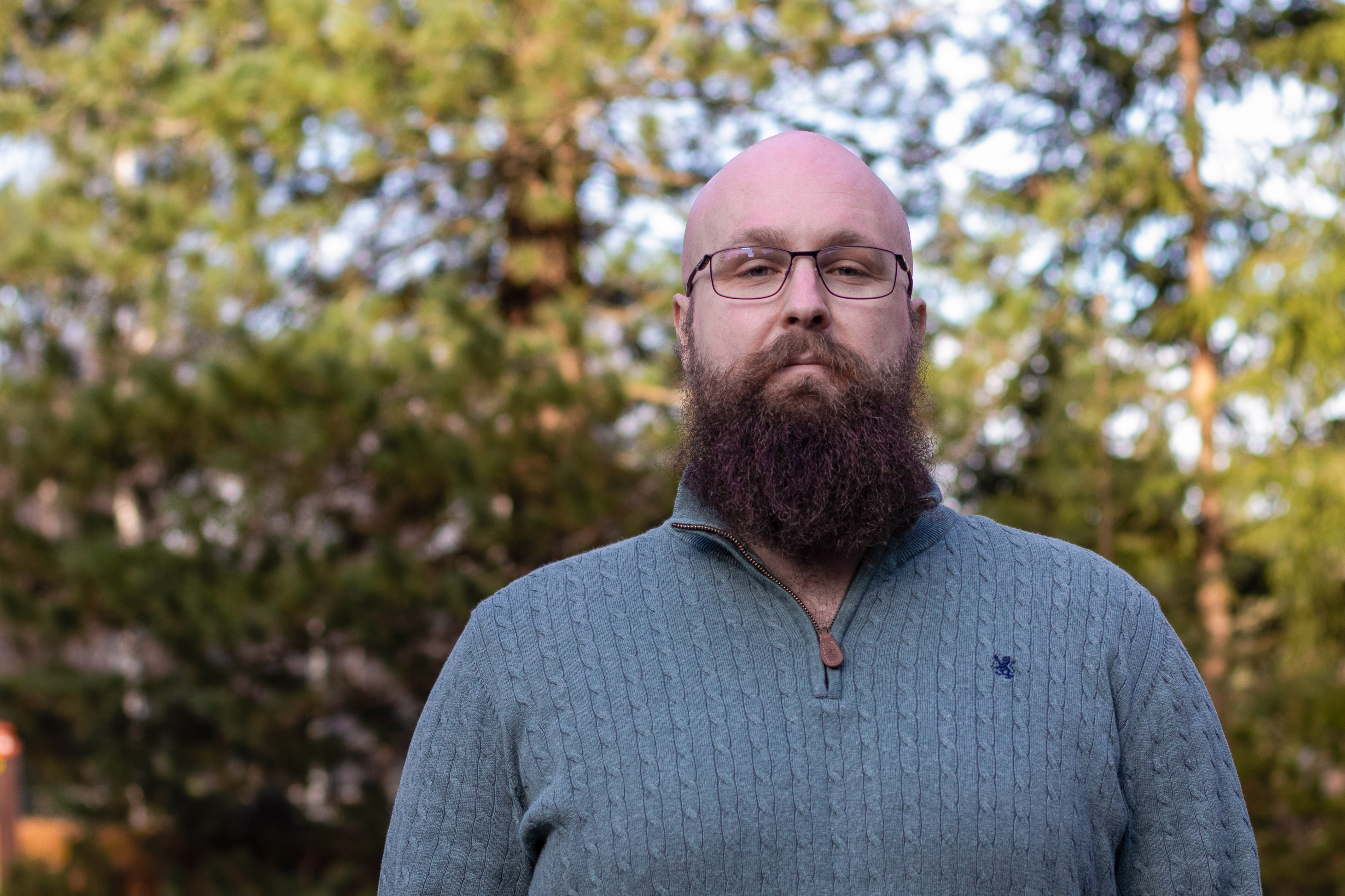 Portrett av Kristian forran en skog.