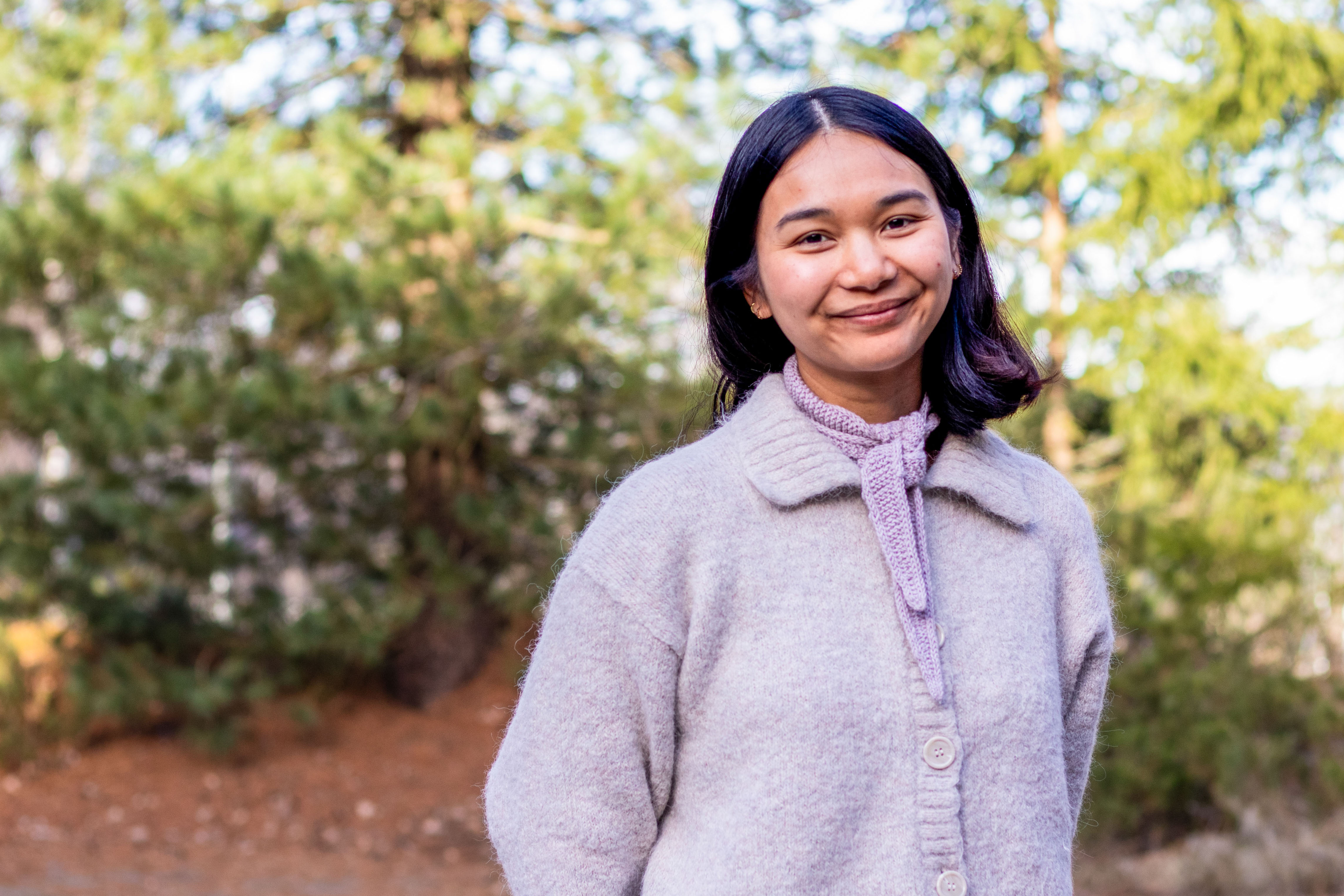 Portrett av Wanwisa Wanpake Johnsrud, skog i bakgrunnen.