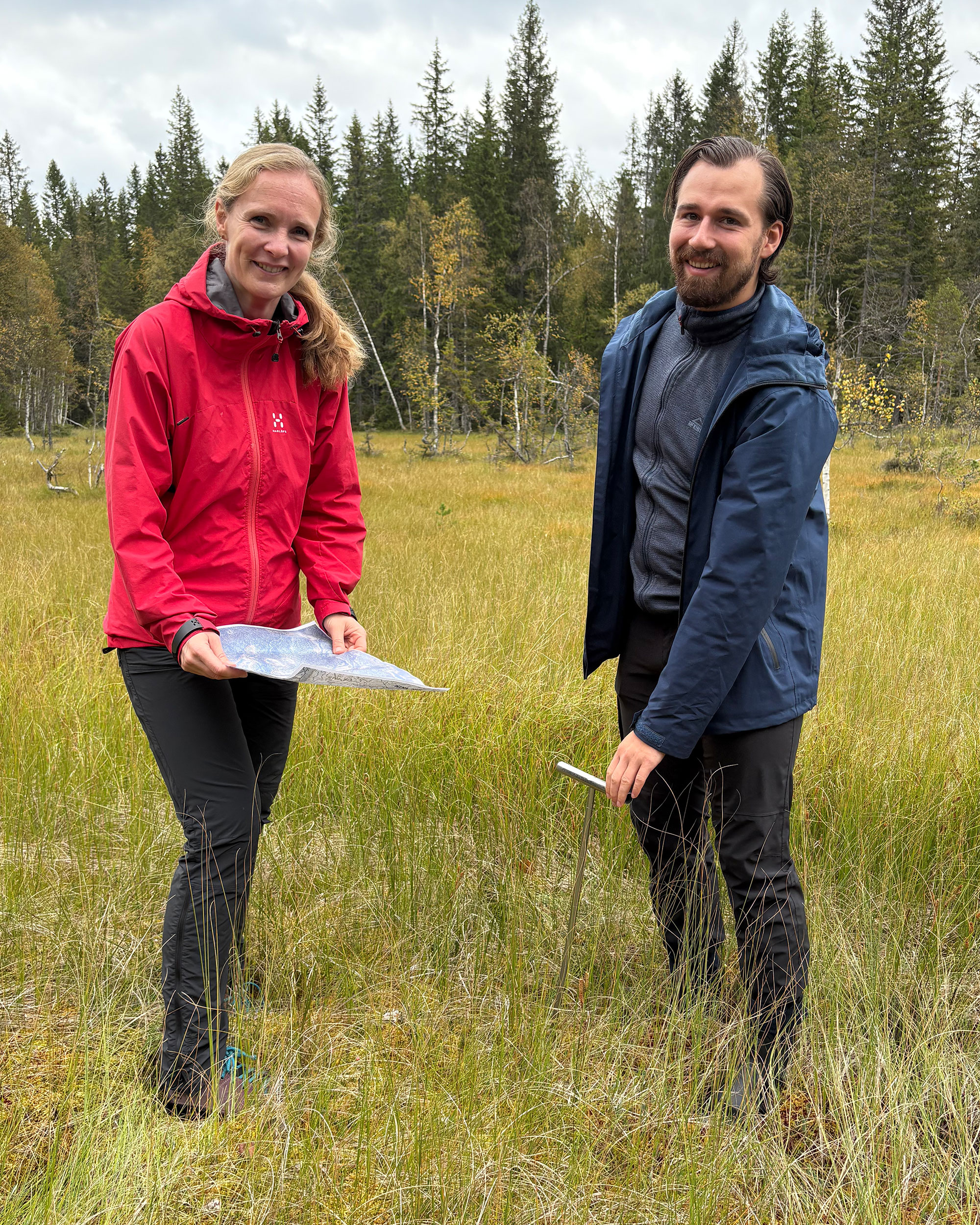 Kvinnelig og mannlig ansatt i Kartverket i ei myr.