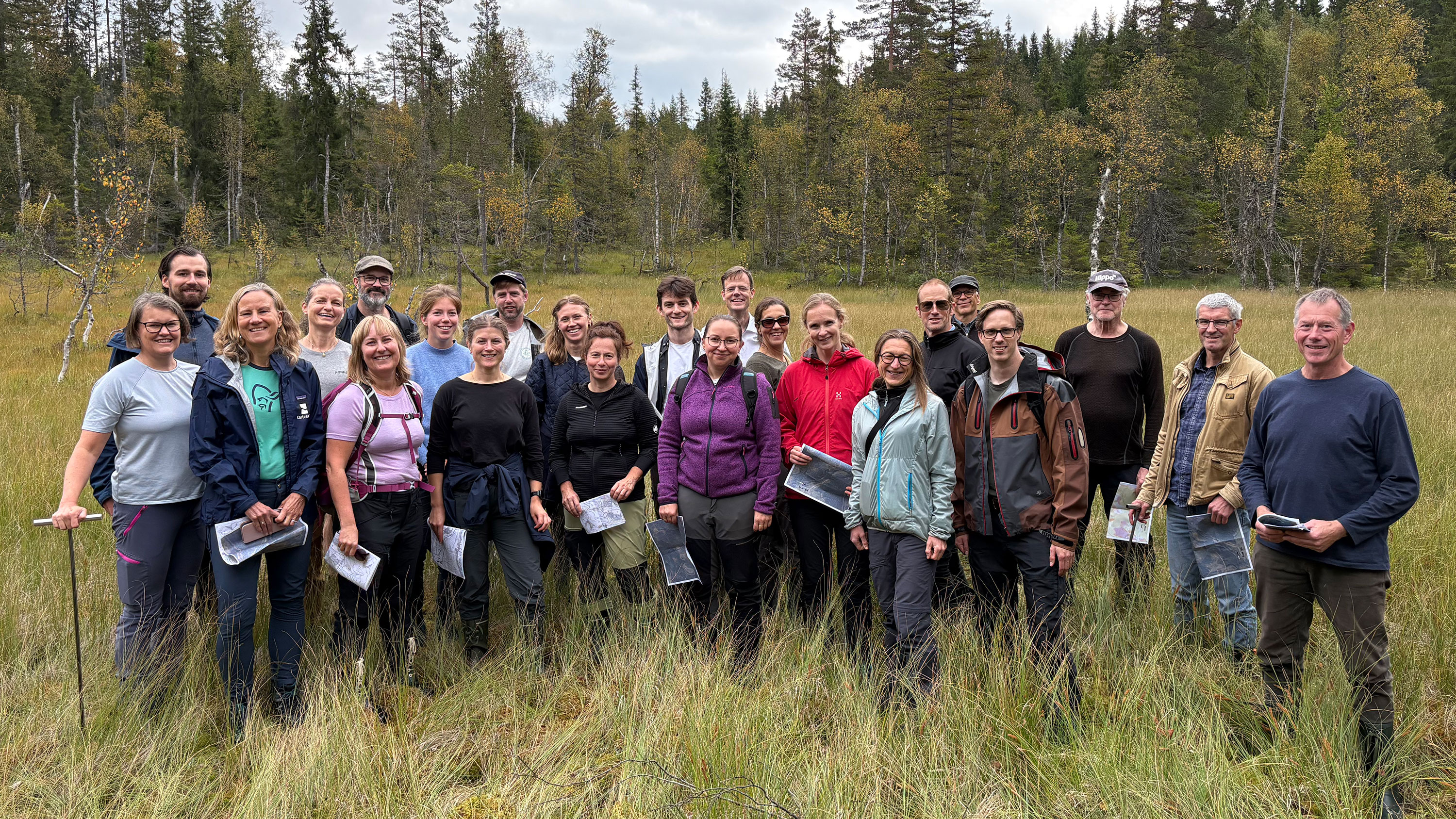 En gruppe personer samla i ei myr