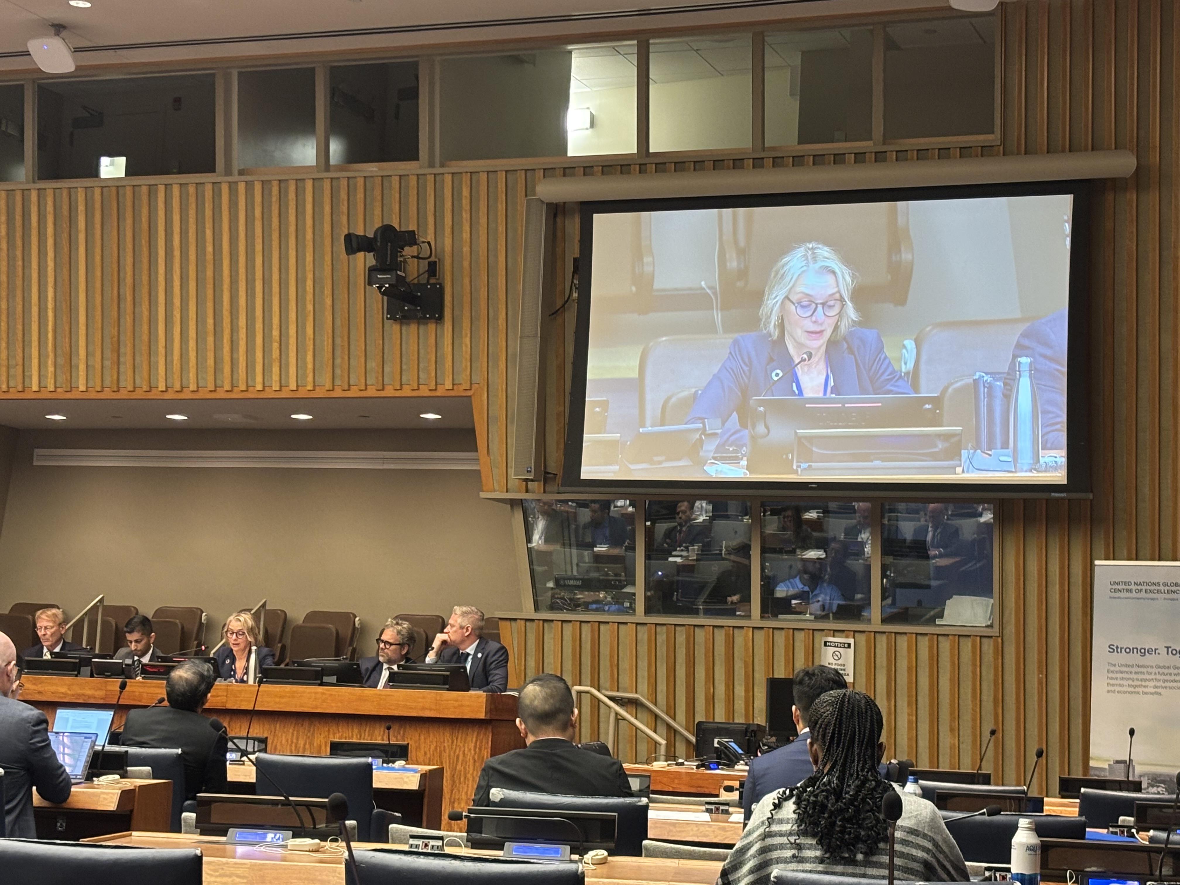 Foto fra FN-bygningen med forsamling foran storskjerm som viser Laila L&oslash;vh&oslash;iden fra Kartverket