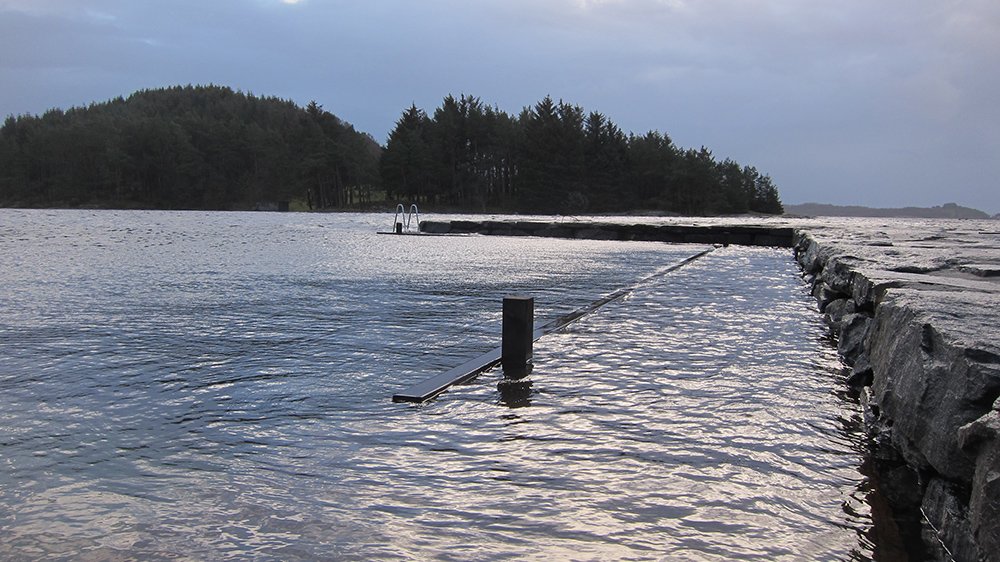A pier being submerged underwater during a period of extra high water level. Photo