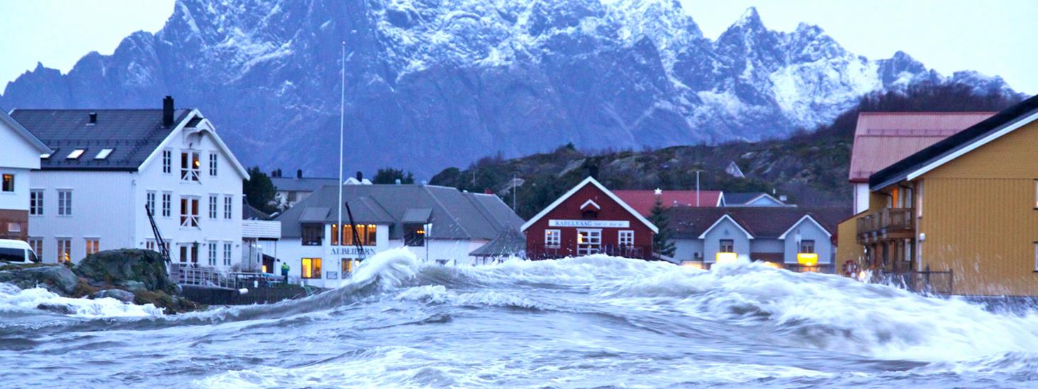 Stormflo slår inn over torget i Kabelvåg i Lofoten. Foto: Jan Ivar Rødli/Promo Norge